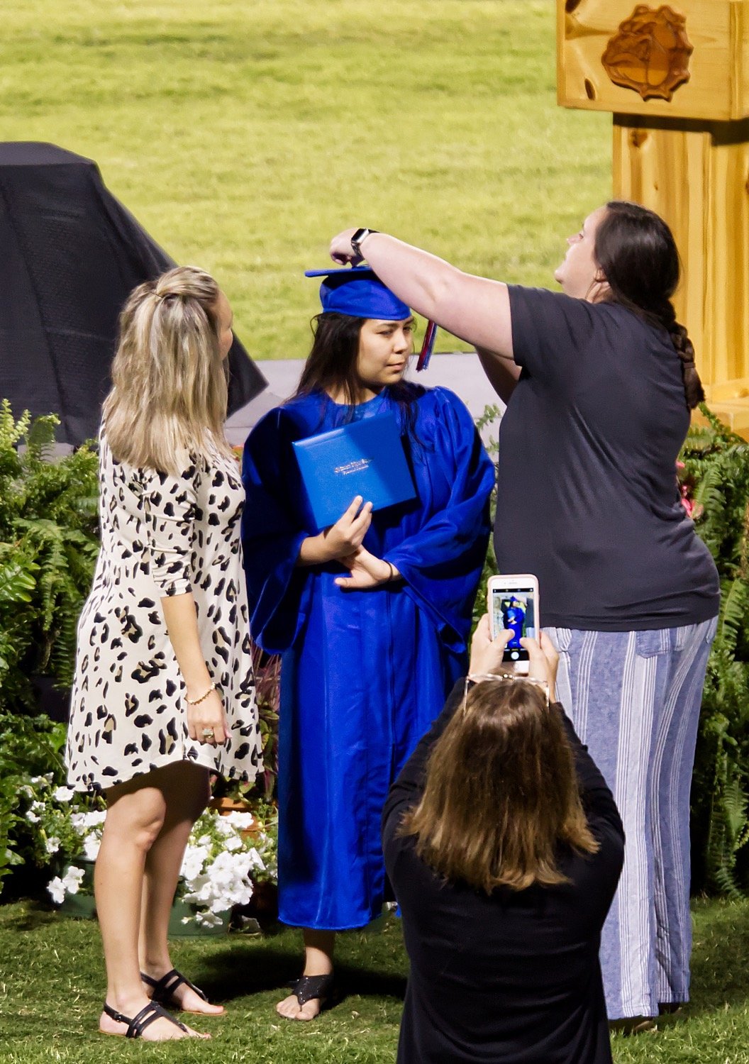 Destiny Martinez gets assistance with her tassel from counselor Julie Cole and Leanne Parish.